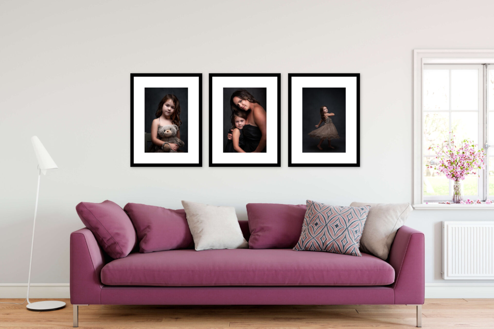 Three framed portraits of a mother and daughter,  hanging on a wall over a purple couch.
